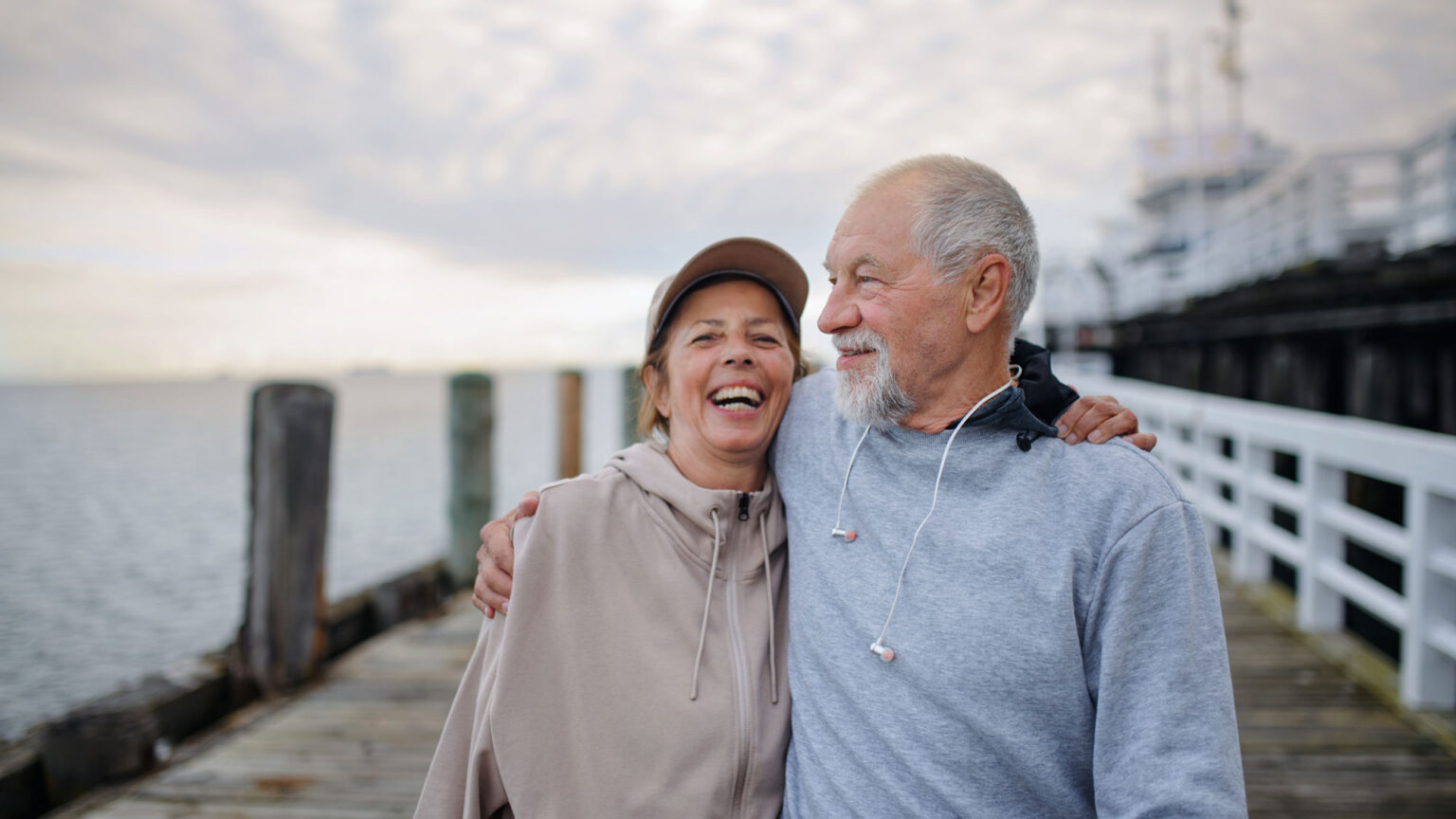 A couple enjoying a brisk walk on a pier, promoting a heart-healthy lifestyle