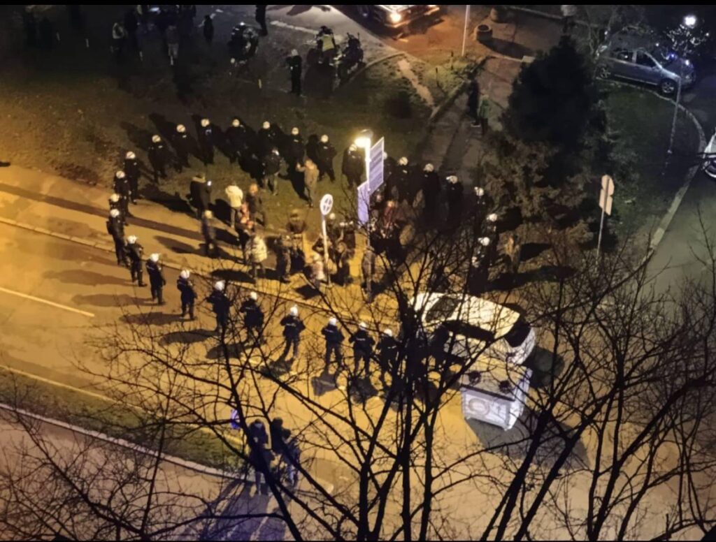 Serbia: small peaceful group protesting against removal of green area, surrounded by police.