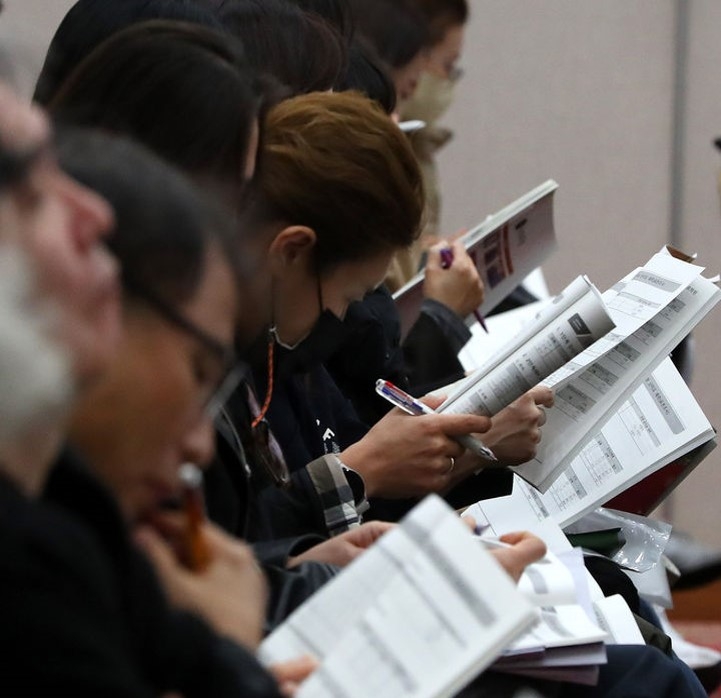 Parents look through college admissions materials at a briefing hosted by Jongro Academy on 2026 regular admissions score predictions and strategies at Sejong University Convention Center in Gwangjin District, Seoul, on Jan. 14. (Newsis)