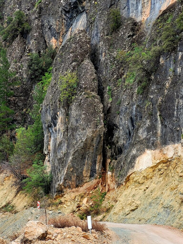 A road with views of massive rocks and a deep blue dam