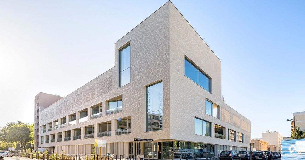 white brick facade wraps school group in france by brenac & gonzalez & associés