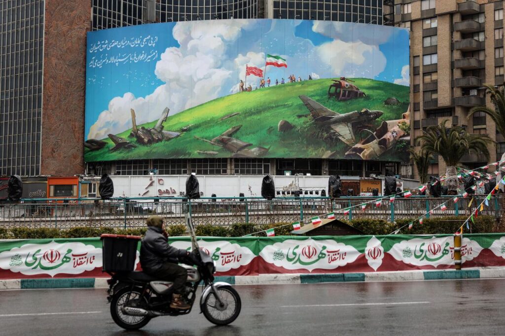 A photograph shows an anti-US billboard displayed on a building in Tehran