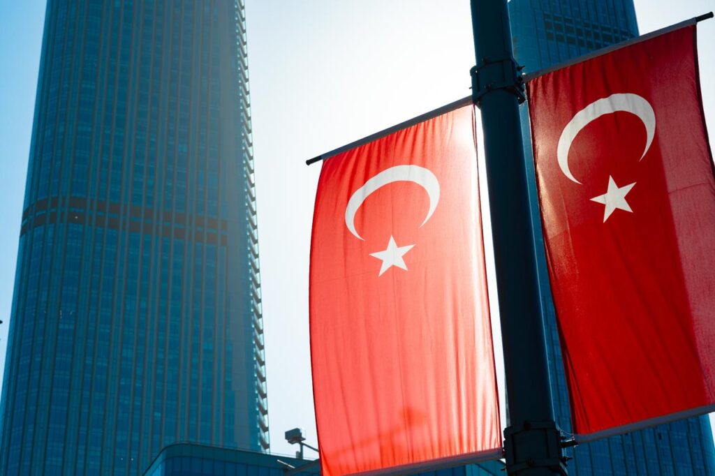 Turkish flags hang in front of skyscrapers in Istanbul, Türkiye. (Adobe Stock Photo)