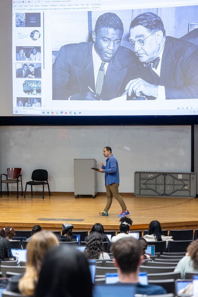 professor walking across stage during class lecture