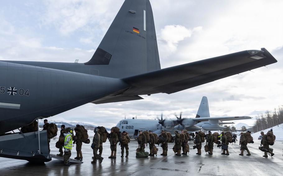 Marines board a C-130 aircraft.