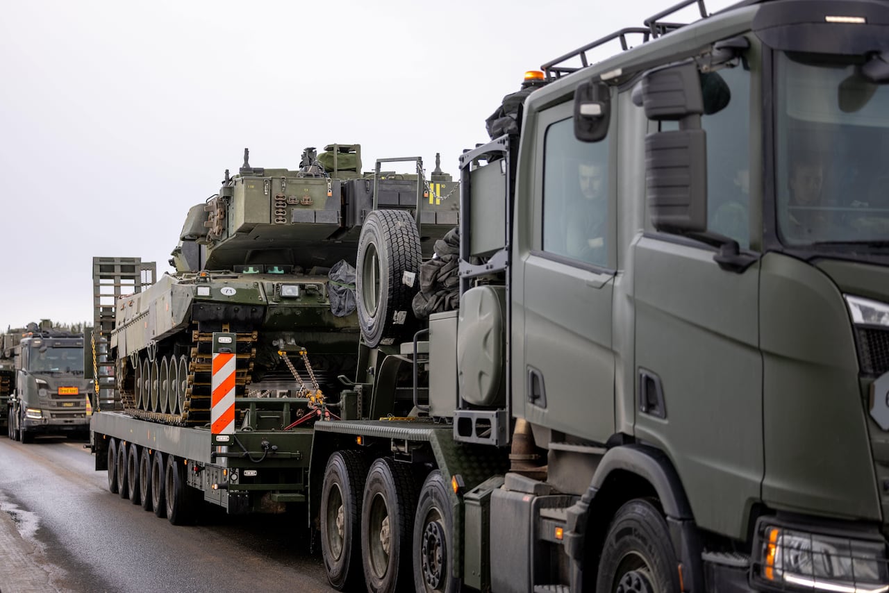 Trucks transport battle tanks.