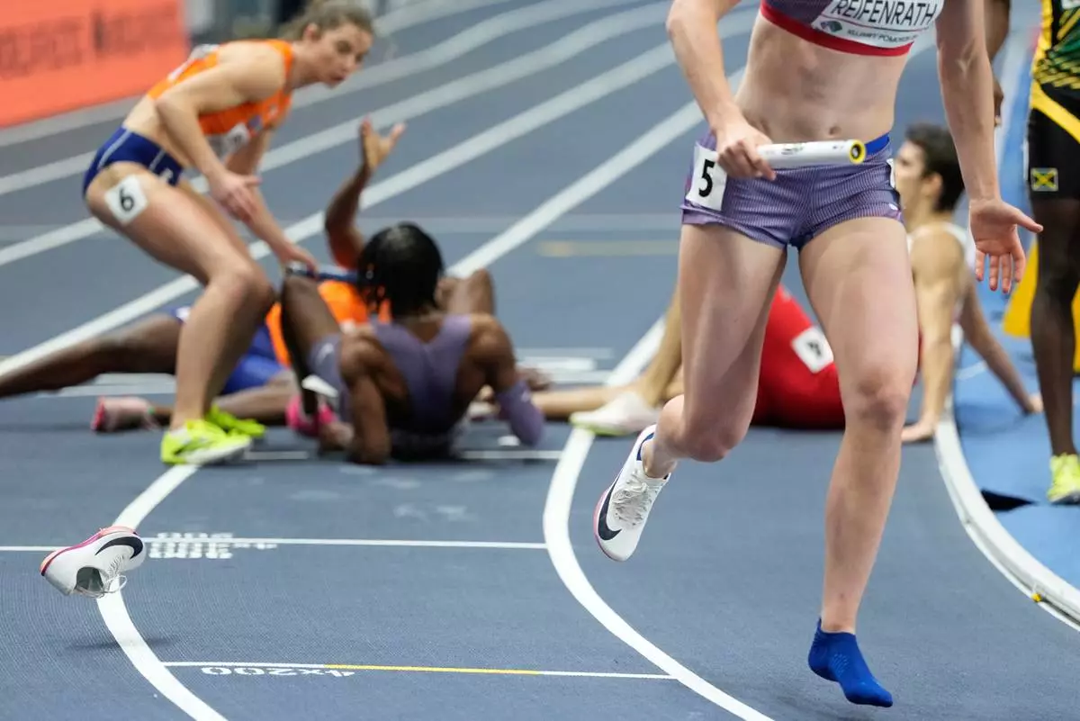 Sara Reifenrath, of the United States, continues the mixed 4 X 400 meters relay, after loosing her shoe at the World Athletics Indoor Championships in Torun, Poland, Saturday, March 21, 2026. (AP Photo/Petr David Josek)