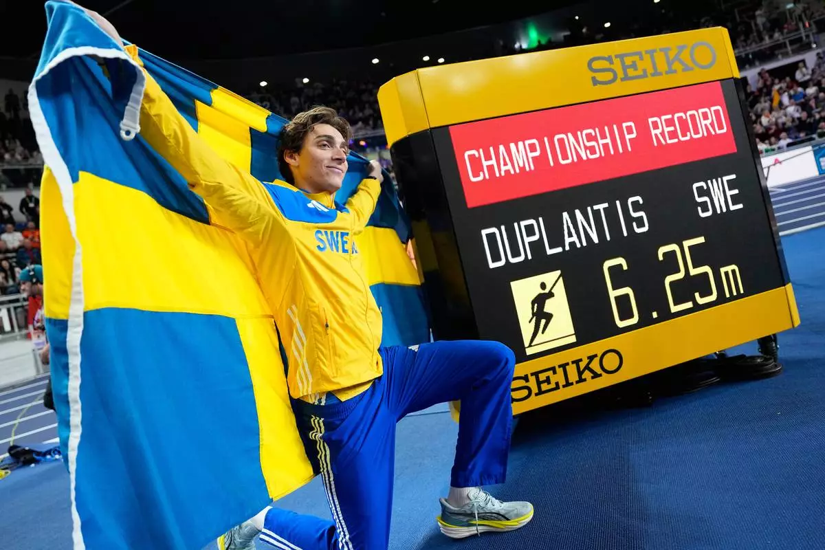 Armand Duplantis, of Sweden, poses after winning the gold medal and setting a new championship record in the men's pole vault final at the World Athletics Indoor Championships in Torun, Poland, Saturday, March 21, 2026. (AP Photo/Matthias Schrader)