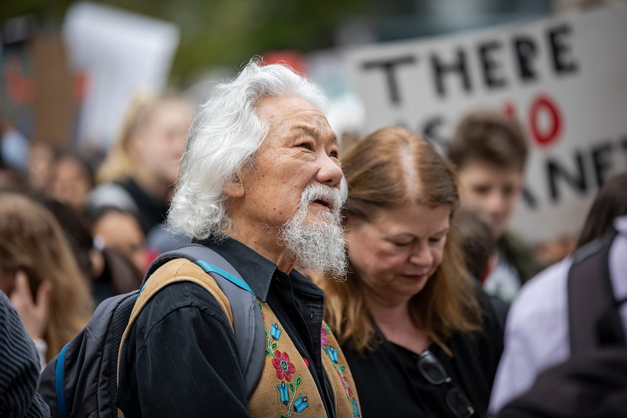 An elderly man looks hopeful at a climate protest
