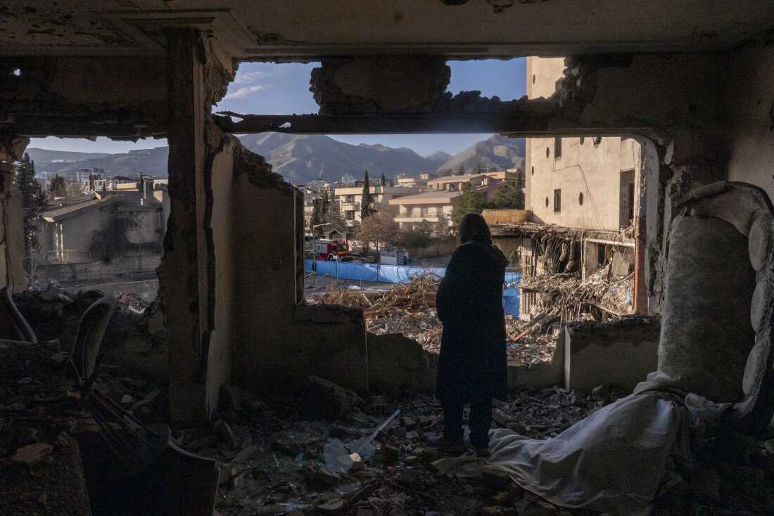 A woman looks out from her destroyed apartment in the remains of a residential and commercial building in the Shahrak-e Gharb neighborhood of Tehran, Iran, on March 21. The building was hit on March 16 amid U.S. and Israeli attacks and resulted in several deaths.