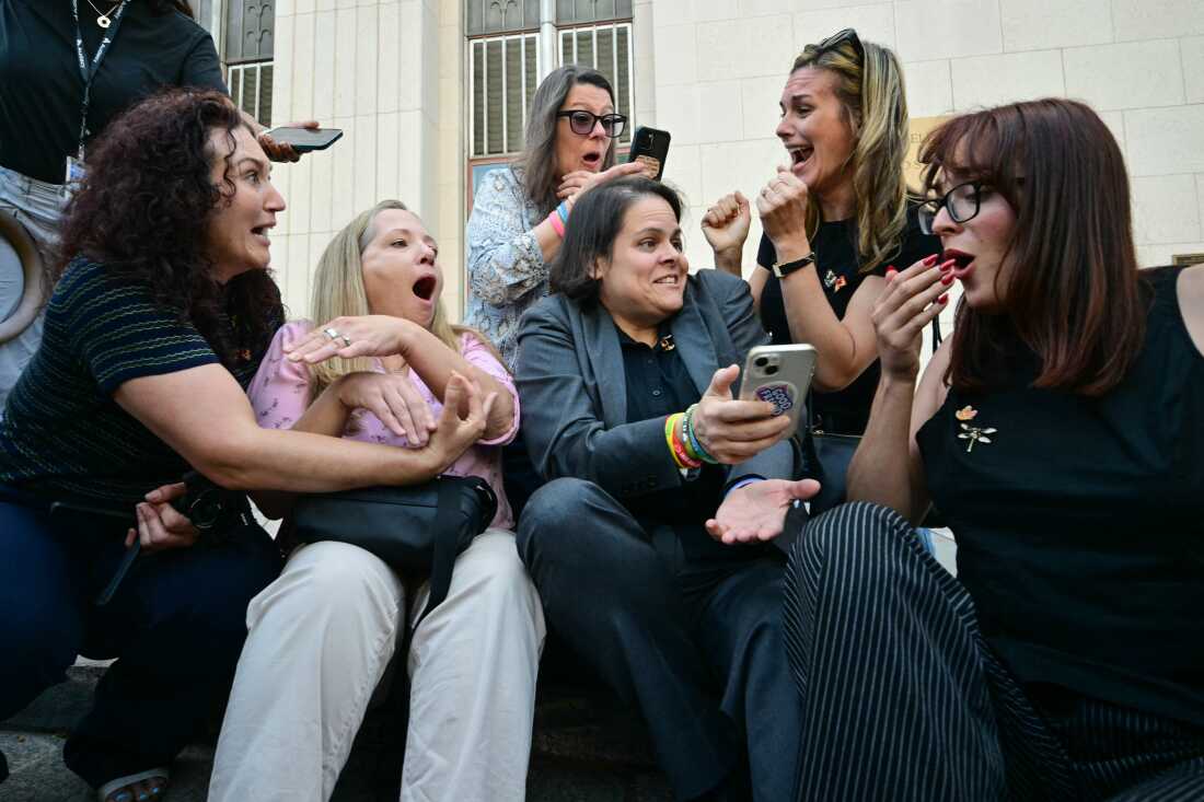 Laura Marquez-Garrett (center), a plaintiffs' attorney for the Social Media Victims Law Center, gathers with family members of victims as they react to news that the jury has found Meta and YouTube liable in the social media addiction trial, outside the Los Angeles Superior Court on March 25, 2026.