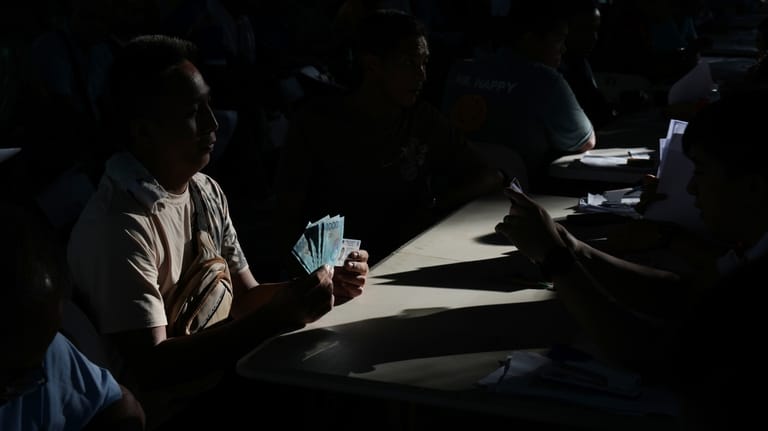 A jeepney driver poses after receiving cash assistance from the...