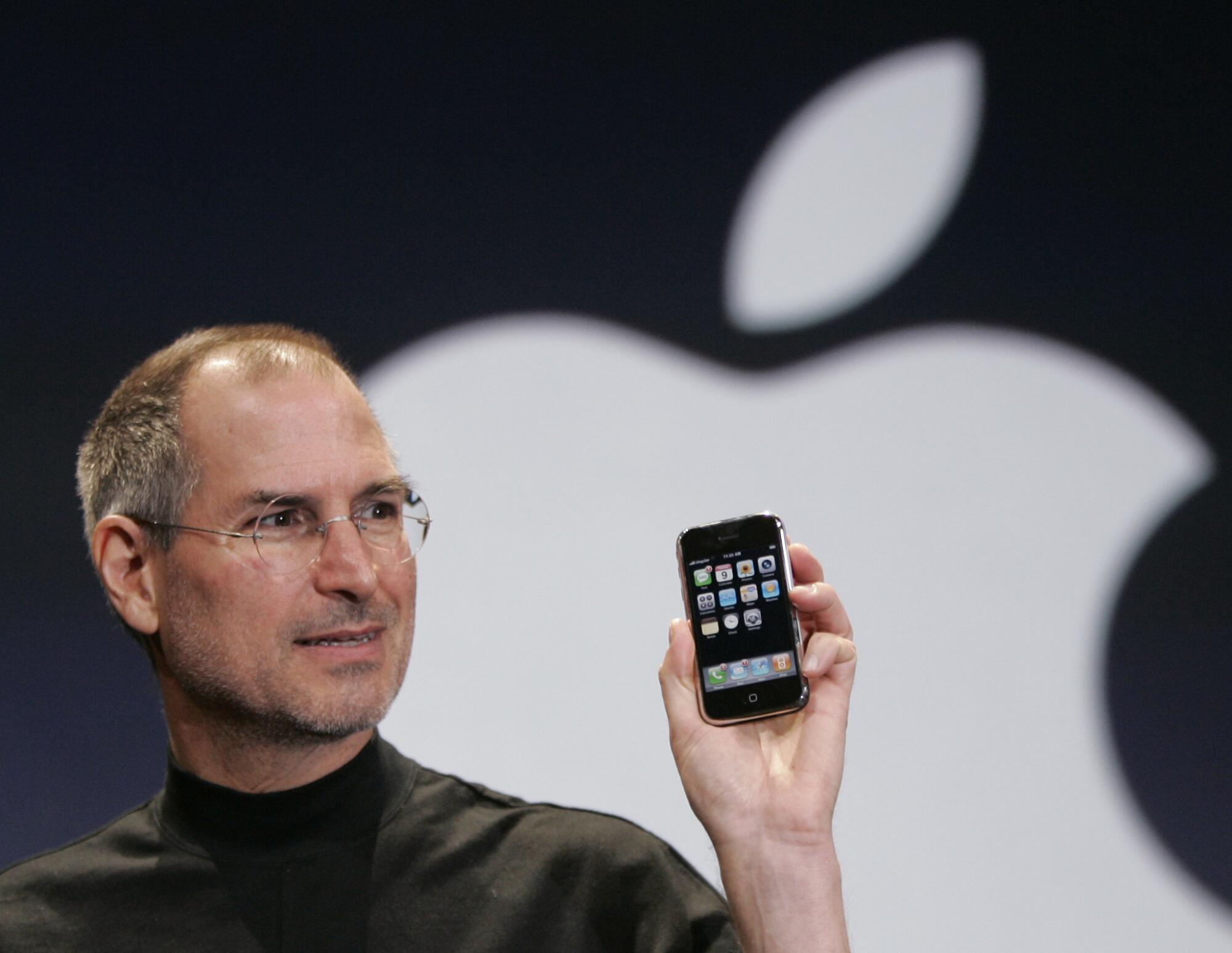 Steve Jobs holds an iPhone in 2007