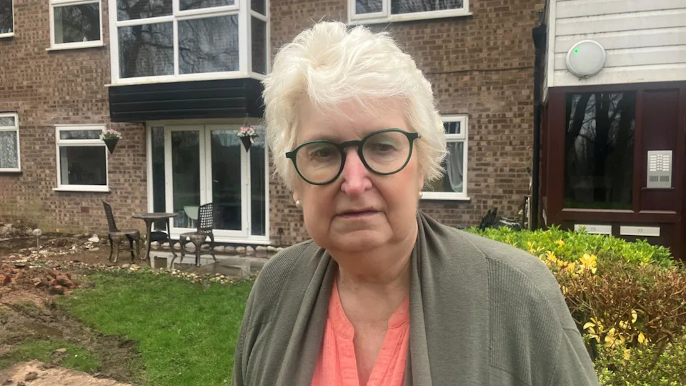 Photograph of Barbara Bushell outside her flat on Heywood Court, Baguley Crescent.