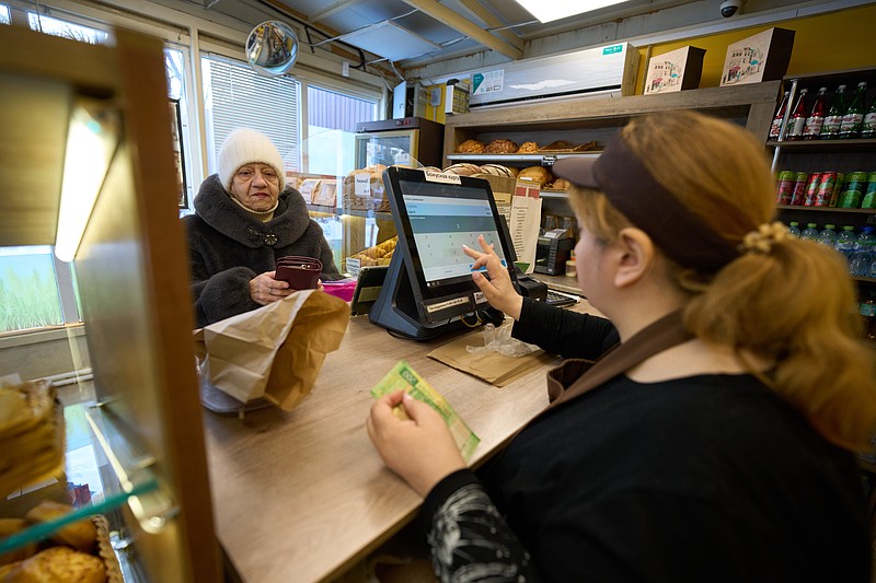 A customer buys bread at the Mashenka bakery outside Moscow, Russia, on Wednesday, Feb. 18, 2026. (AP Photo/Alexander Zemlianichenko)