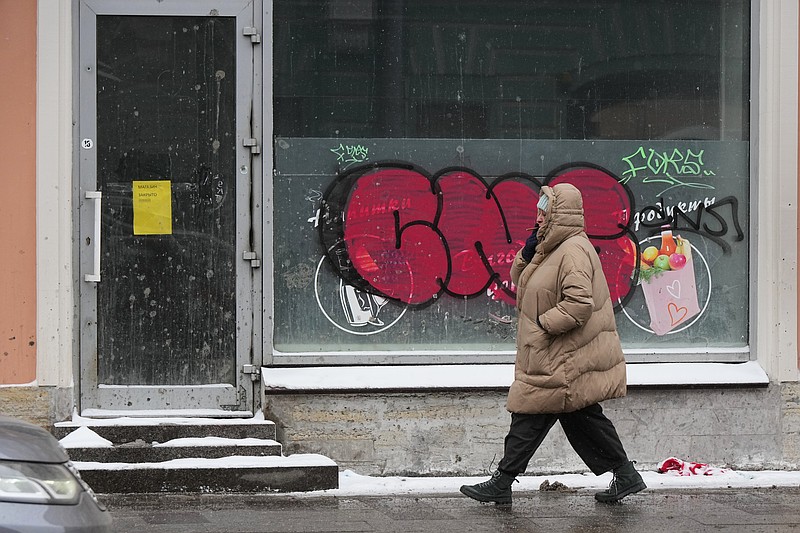 A woman walks past a closed grocery shop in St. Petersburg, Russia, Friday, Feb. 20, 2026. (AP Photo/Dmitri Lovetsky)