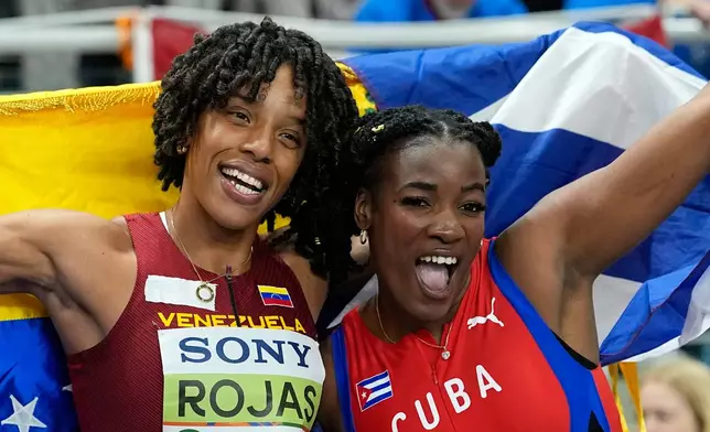 Gold medalist Leyanis Perez Hernandez, of Cuba, and silver medalist Yulimar Rojas, of Venezuela, pose after the women's triple jump final at the World Athletics Indoor Championships in Torun, Poland, Saturday, March 21, 2026. (AP Photo/Matthias Schrader)
