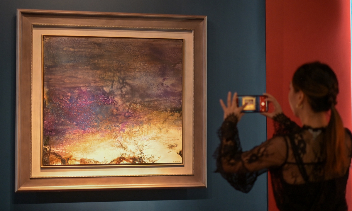A viewer takes a photo of one of Zao Wou-Ki's artworks on in China's Hong Kong Special Administrative Region HKSAR. Photo: VCG 
