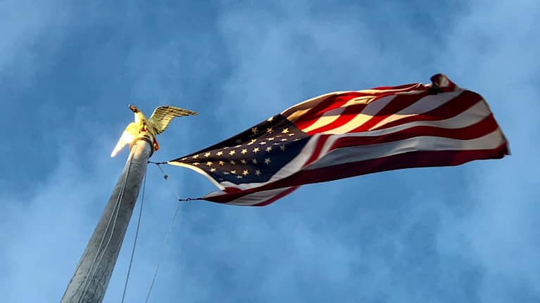 The American flag against a blue sky.