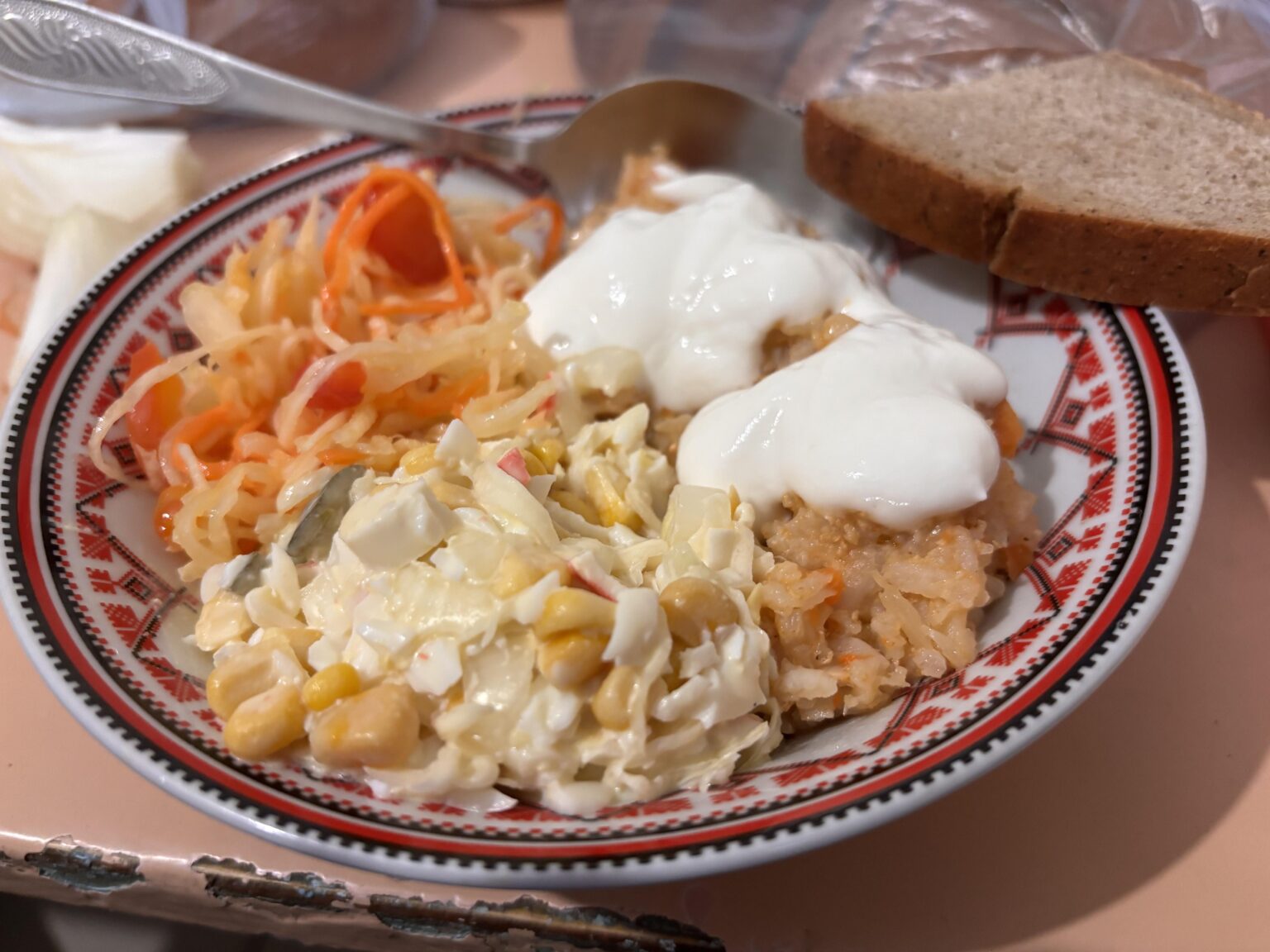 Today's dinner in my military unit: pilaf with meat (topped by smetana / sour cream), crabstick salad, and cabbage salad