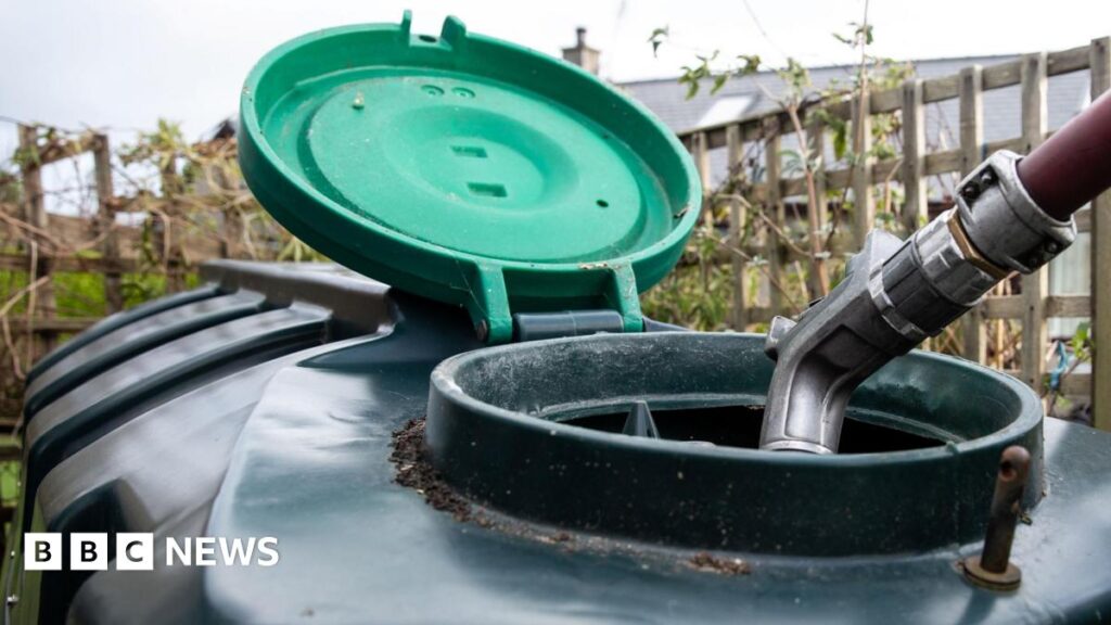 Swinney – UK government must ‘get a move on’ with heating oil support A large plastic heating oil tank in a garden with its top open and a hose filling it.