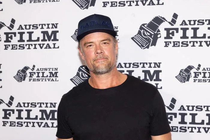 Josh Duhamel in casual black shirt and cap at Austin Film Festival backdrop