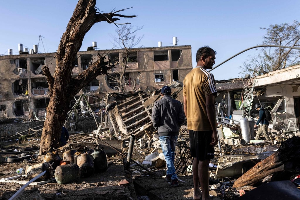 People inspect the site of an Iranian missile strike in Dimona, Israel, on Sunday. More than 100 people were injured in the attack. Photo: AFP