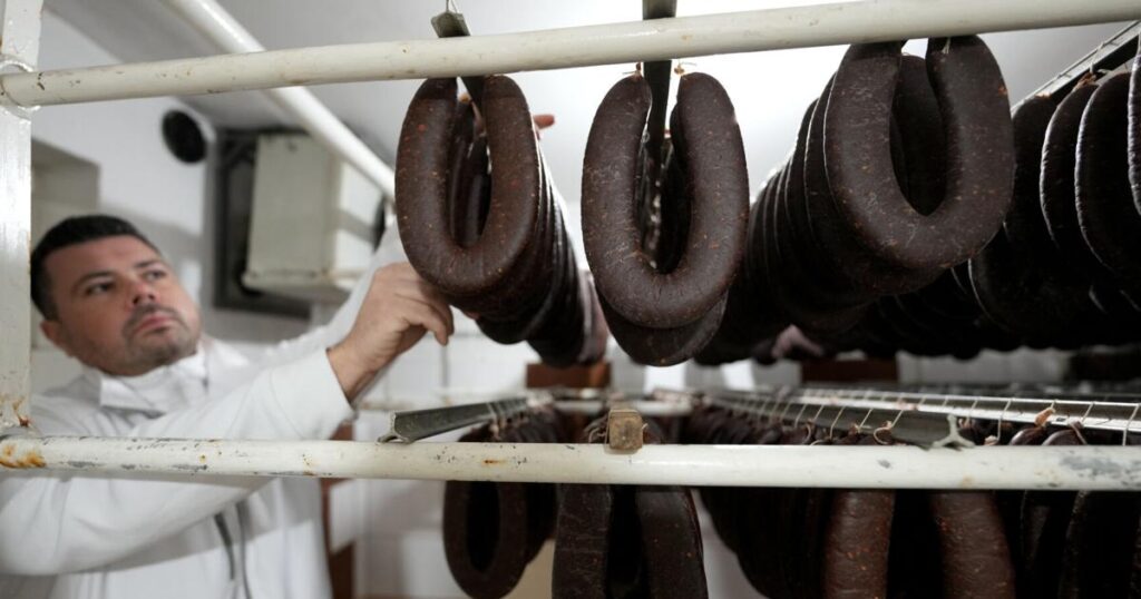 A traditional sausage in the shape of a horseshoe is 'ironed' for dryness in southeastern Serbia | Food