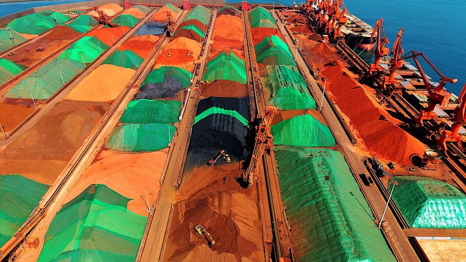 Construction machinery is transporting imported iron ore at the Qingdao Port Ore Terminal in Qingdao, Shandong Province.
