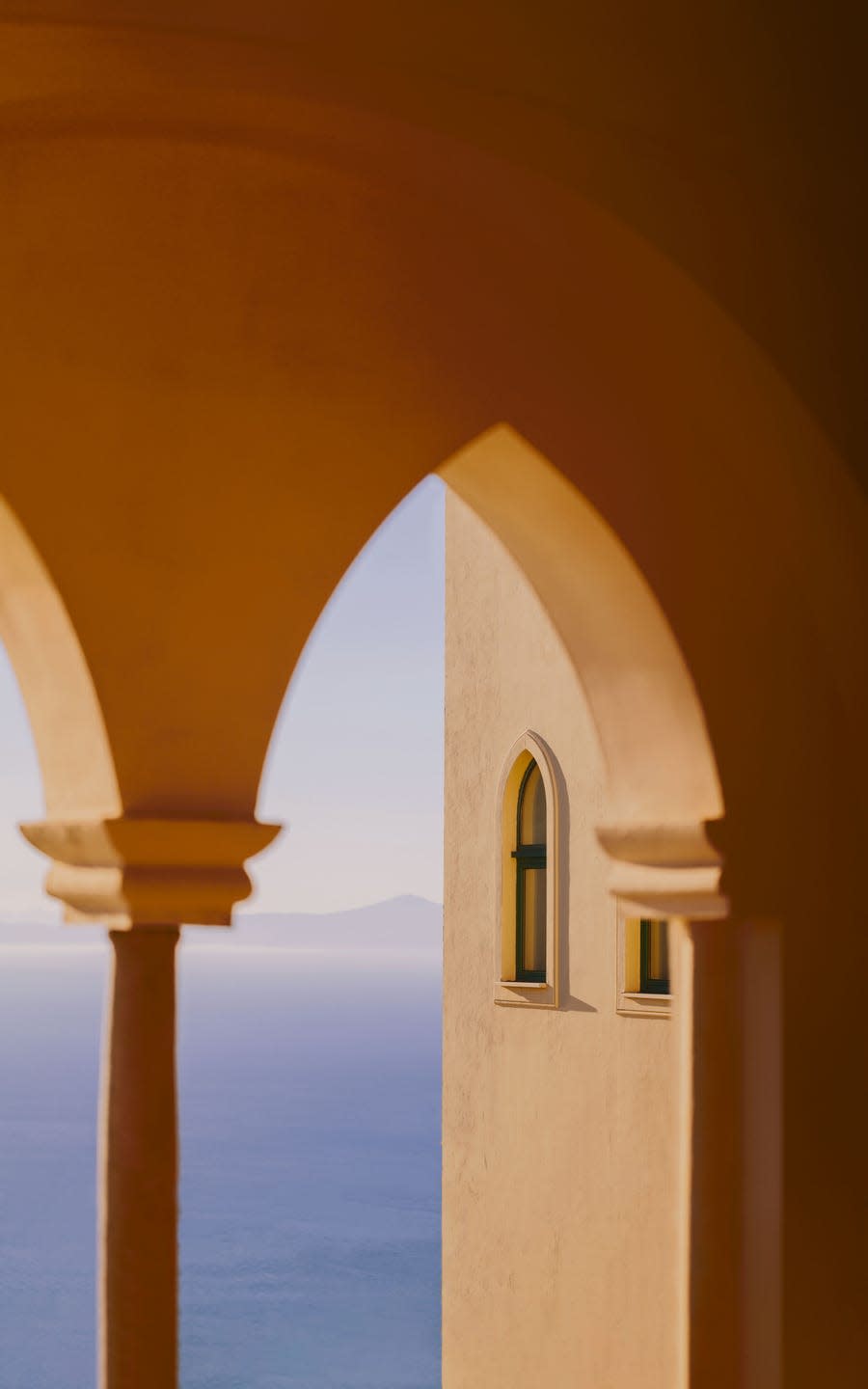 a traditional european archway through which the sea can be seen