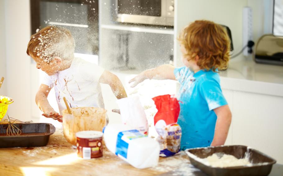 Brothers, baking and flour with children fighting in the kitchen while making a mess of their home together. Cooking, recipe and ingredients with boy kids arguing about instructions in a house.