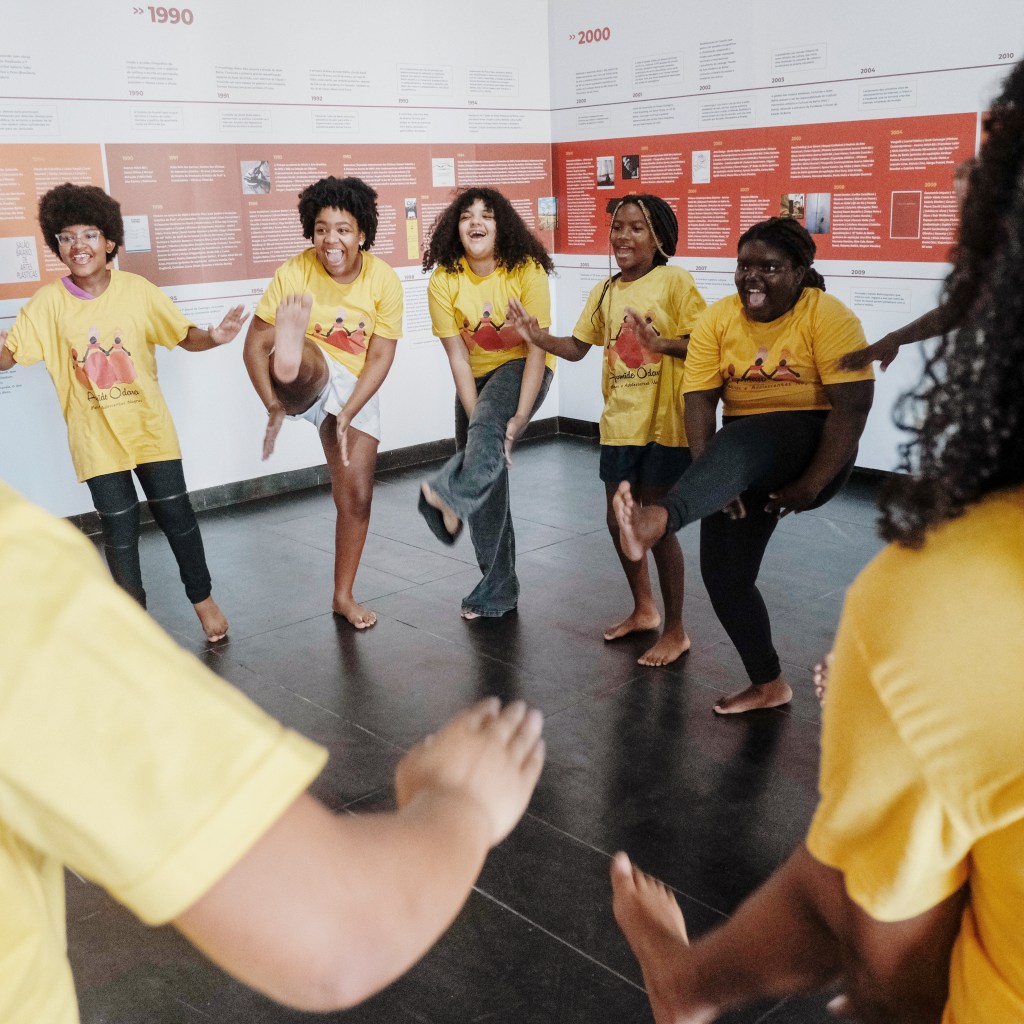 Image of young Brazilian children partaking in programming, smiling.
