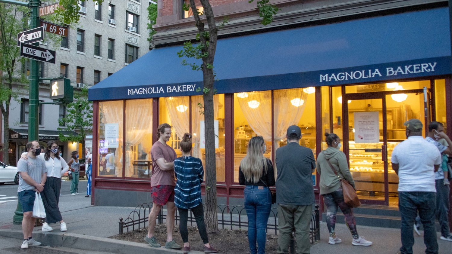 Sex and the City filming location-People wearing masks wait in line outside of Magnolia Bakery on the Upper West Side.