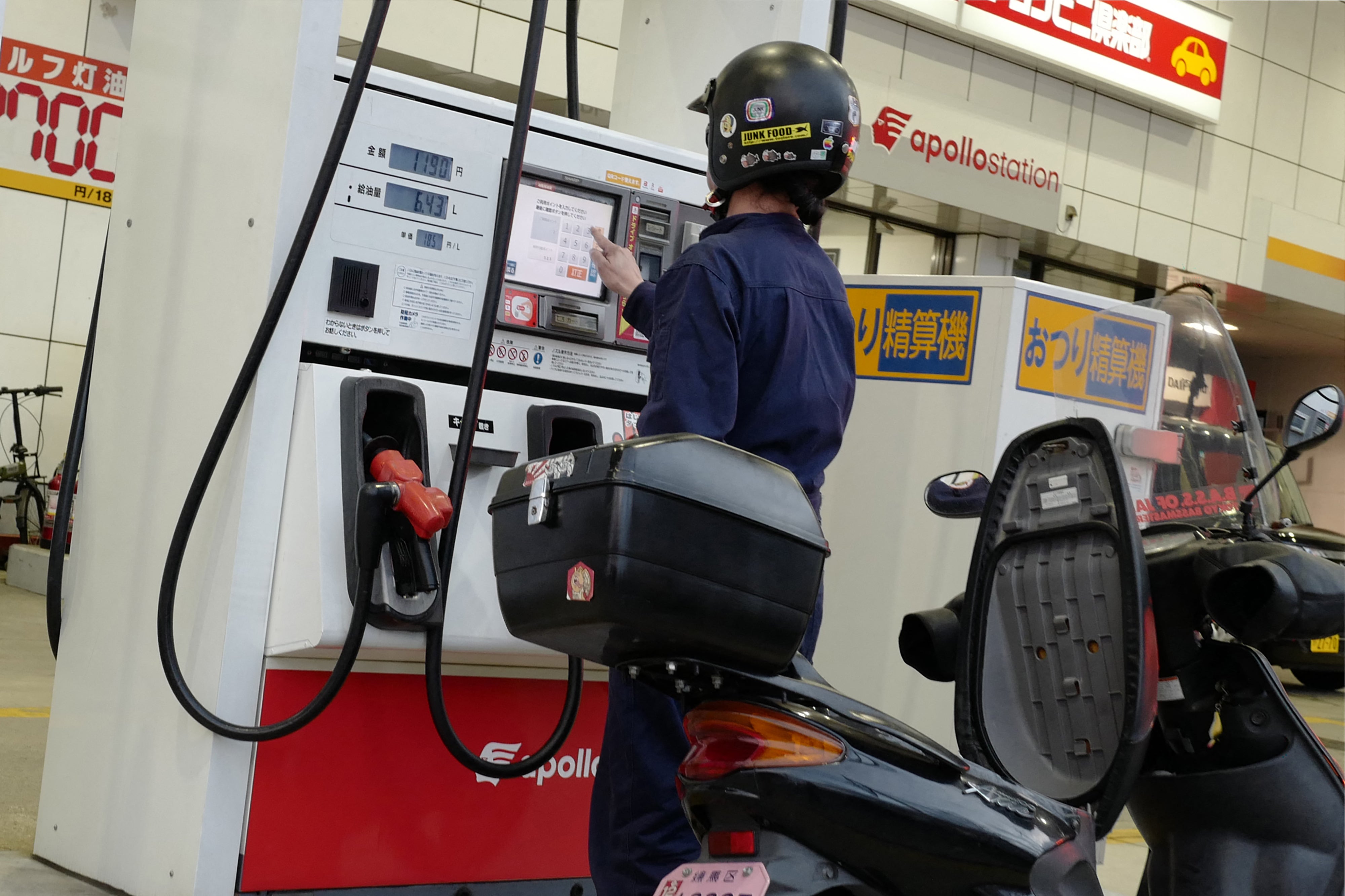 A man refuels a motorcycle at a gas station in Tokyo on March 18, 2026