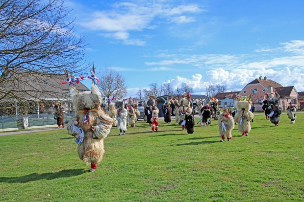 Kurents make a mad dash on their way to another home during door-to-door rounds in Spuhlja, Slovenia. (Photo by Norma Meyer)