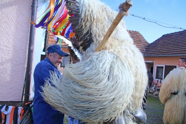 A Kurent greets a homeowner during door-to-door visits in Spuhlja, Slovenia. (Photo by Norma Meyer)