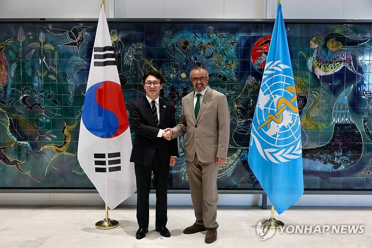 South Korean Prime Minister Kim Min-seok (L) poses for a photo with Tedros Adhanom Ghebreyesus, director-general of the World Health Organization (WHO), during their meeting at the WHO headquarters in Geneva on March 17, 2026, in this photo released by Kim's office. (PHOTO NOT FOR SALE) (Yonhap)