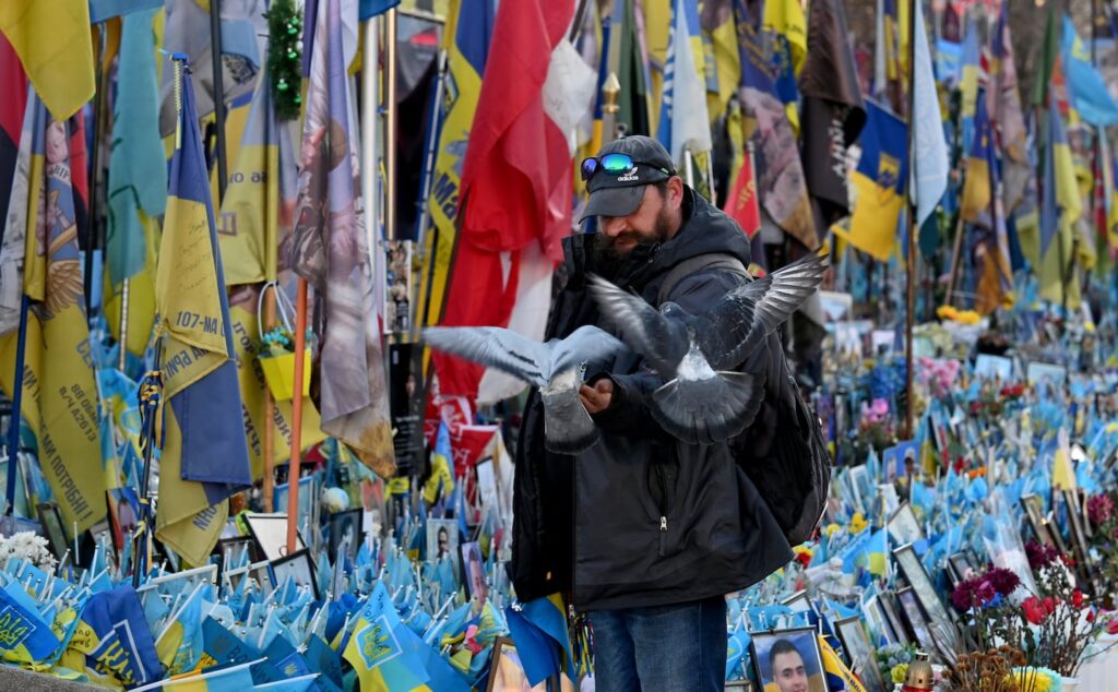 Ukrainian forces halt advance in Zaporizhzhia, Kyiv officials say A man fed pigeons in front of a makeshift memorial for fallen Ukrainian and foreign soldiers in Independence Square in Kyiv on Saturday.