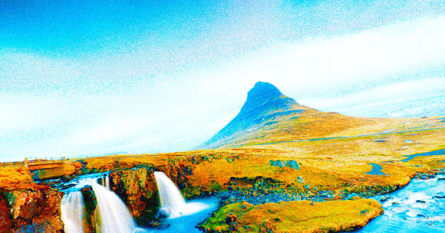 Airline Wants a ‘Really Bad Photographer’ and it Might Be the Best Gig of the Year A grassy landscape with a small waterfall in the foreground and a distinctively shaped mountain under a bright, mostly clear sky.