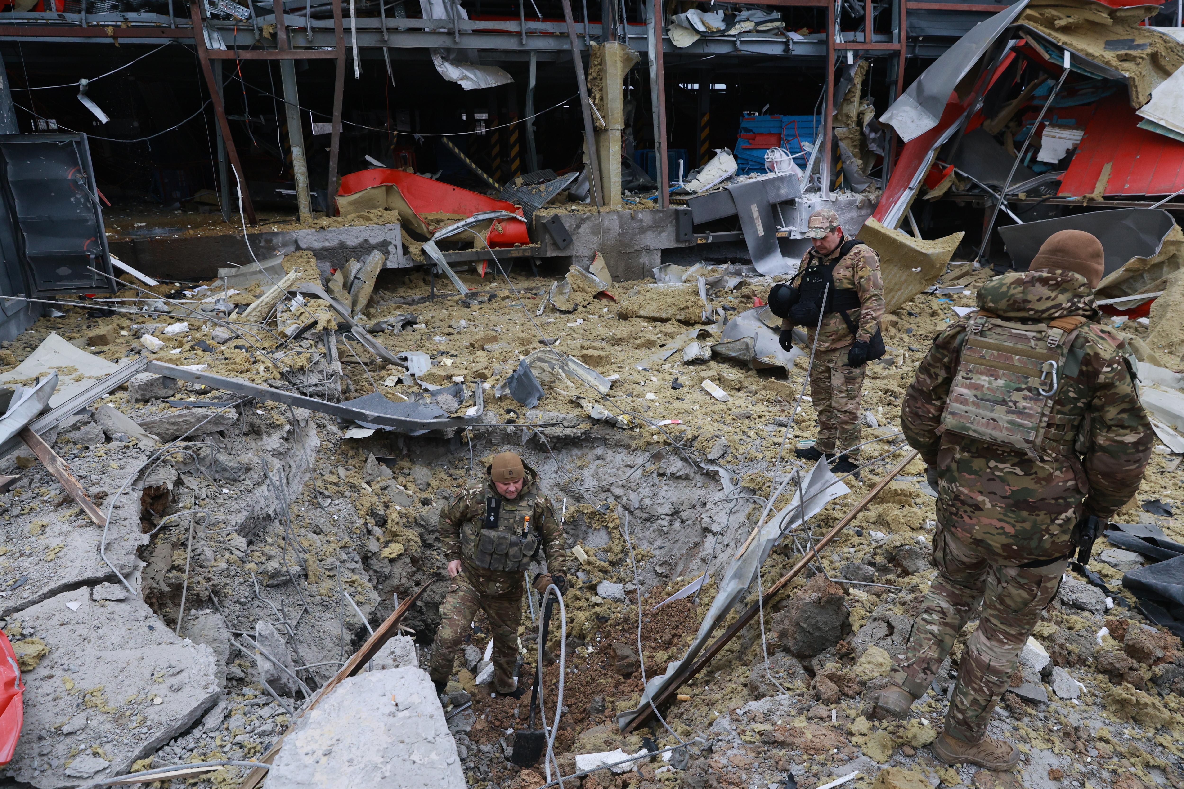 Sappers examine the site of a Russian missile strike, which hit a Ukrainian post office storehouse.