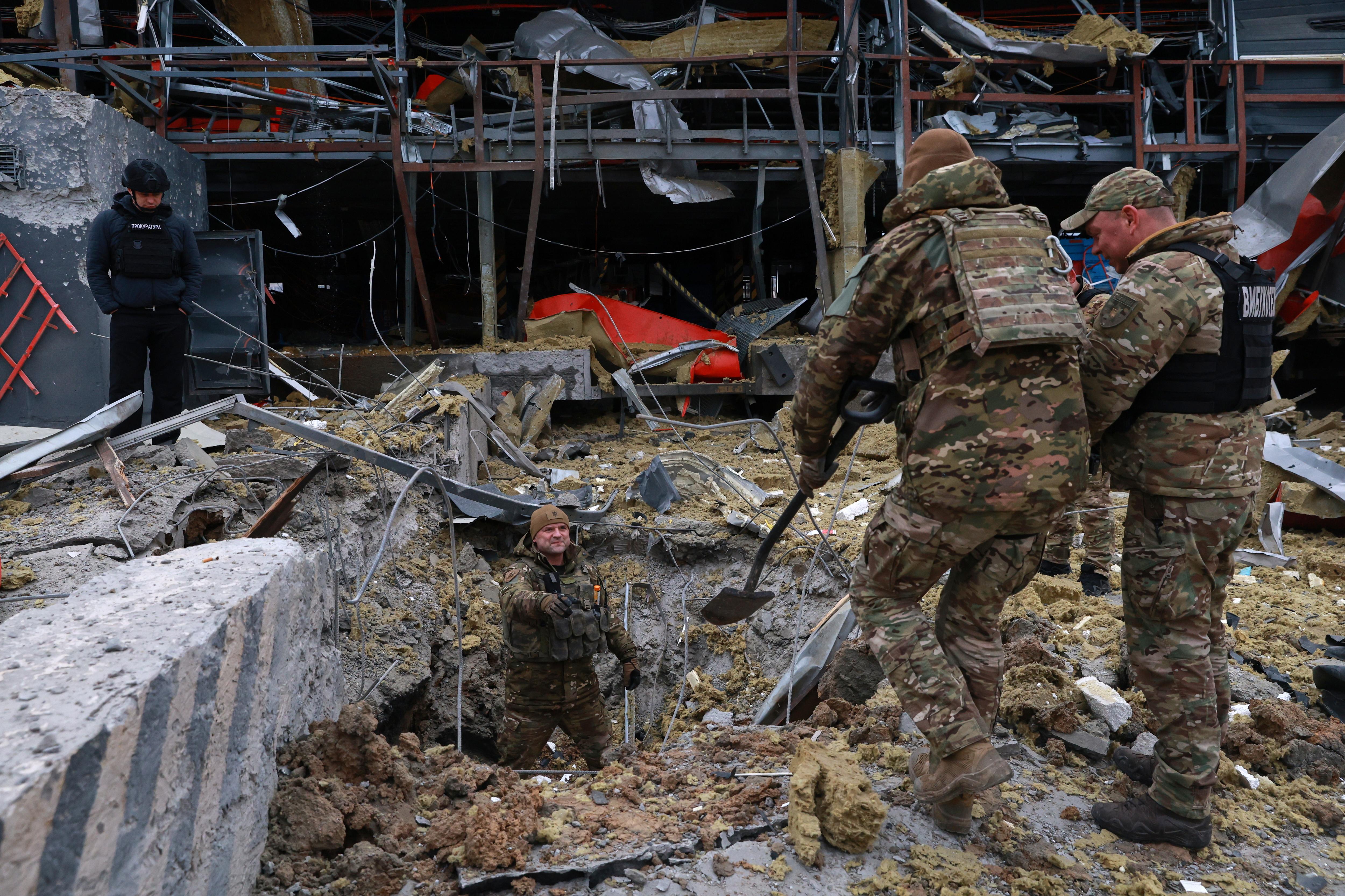 Sappers examine the site of a Russian missile strike, which hit a Ukrainian post office storehouse.