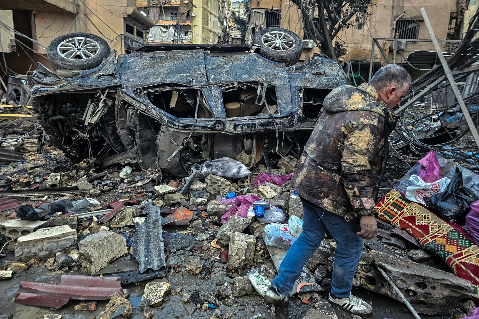 A man walks past the destruction at the site of overnight Israeli airstrikes in the southern suburbs of Beirut on March 16, 2026. The Israeli military said on March 16 it had begun what it described as 