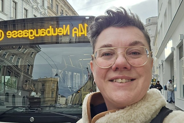 Sarah Bishop taking a selfie in front of a tram on a street in Vienna