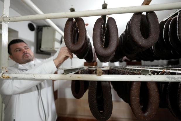 Misa Rajic hangs ironed sausages at his home in Pirot, Serbia, on Feb. 13, 2026. (AP Photo/Darko Vojinovic)