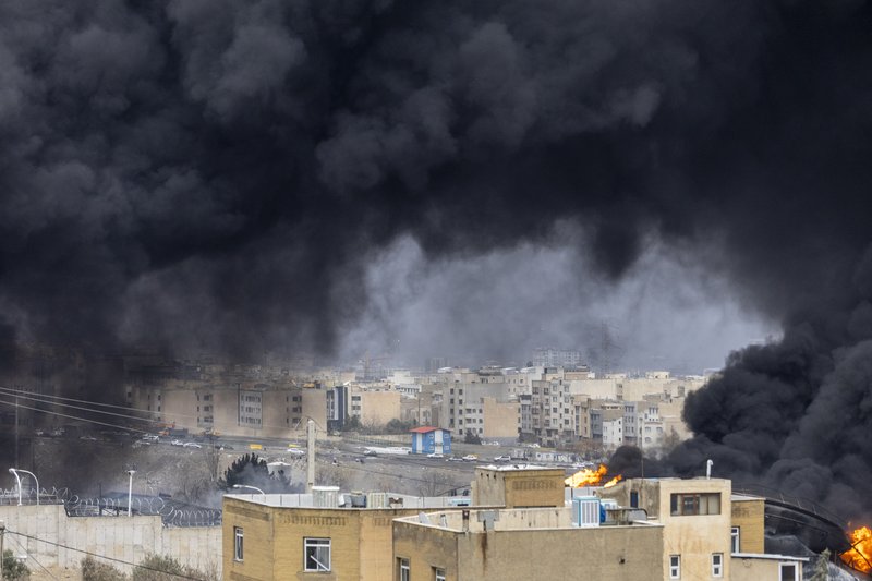Black smoke rises over Tehran, Iran, after overnight airstrikes on oil depots in the area on 8 March