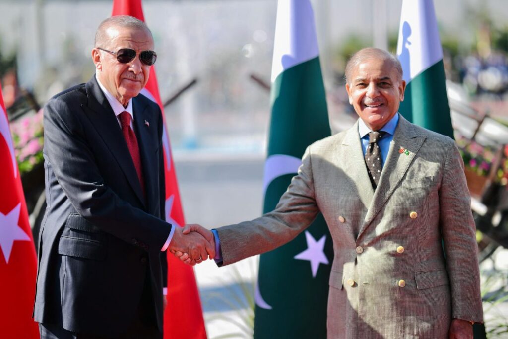 Turkish President Erdogan and Pakistani Prime Minister Shehbaz Sharif shake hands during a diplomatic meeting, as Turkey expresses readiness to support ceasefire efforts between Pakistan and the Taliban amid rising regional tensions. (Photo Credit: PAKISTAN'S PRIME MINISTER OFFICE / AFP)