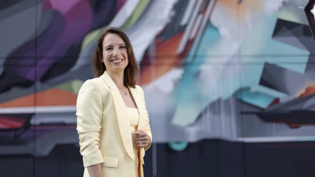 AI@Work in Business | UNC Greensboro Marketa Rickley of UNCG BSBE stands on front of a colorful background.