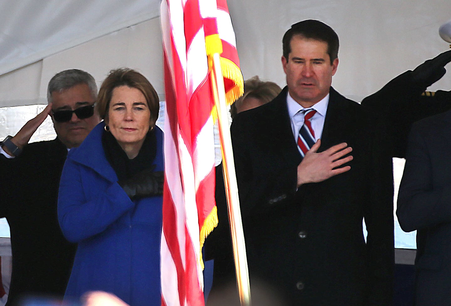 Mass Gov. Maura Healery and Congressman Seth Moulton  stood as the colors are presented at the start of a ceremony.