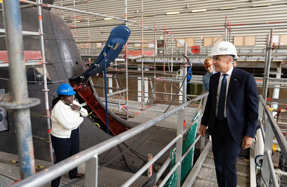 Prime Minister Mark Carney looks over a 212A class submarine under maintenance as he tours Thyssenkrupp Marine Systems (TKMS), a submarine building facility in Kiel, Germany on Tuesday, Aug. 26, 2025. THE CANADIAN PRESS/Christinne Muschi