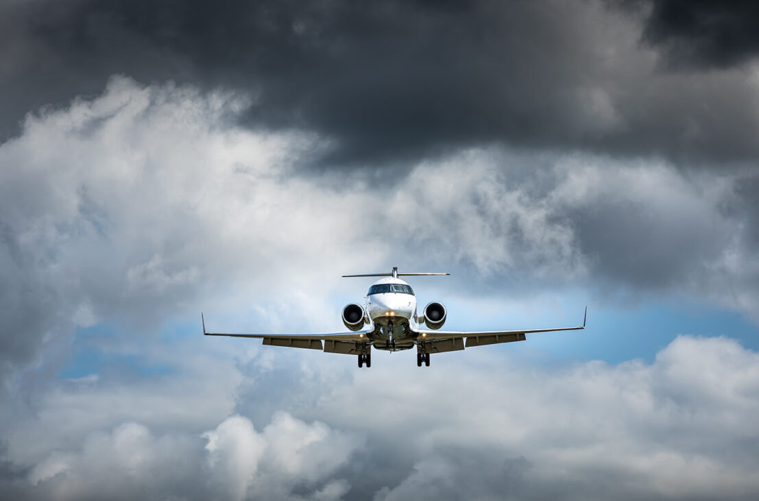 Business jet flying in ominous storm clouds